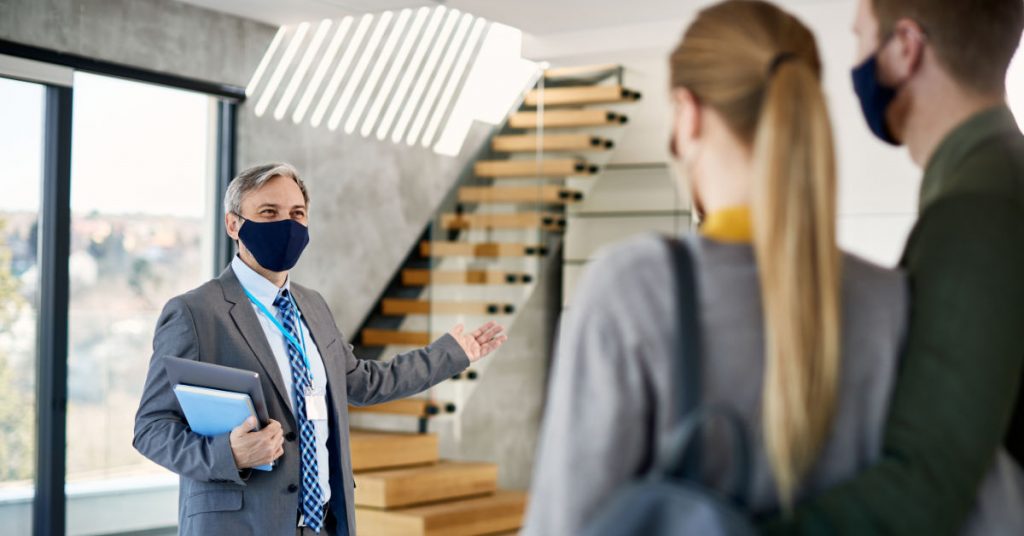 Realtor showing home to buyers during COVID 19 pandemic